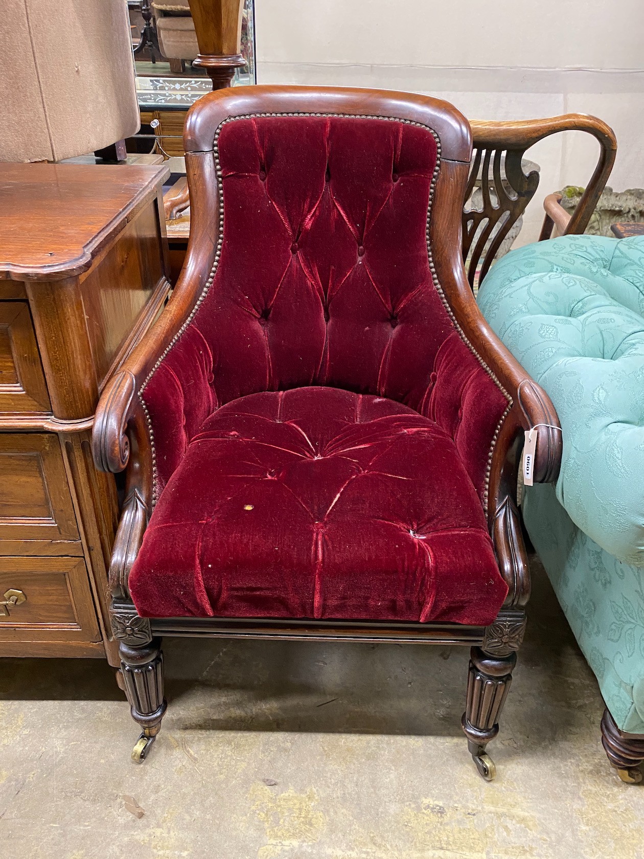 A Regency mahogany bergere chair now upholstered in a deep buttoned red fabric, width 59cm, depth 65cm, height 97cm